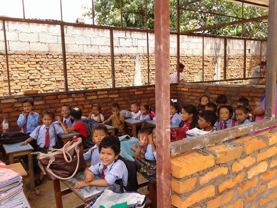 A volunteer from Projects Abroad pictured a group of children having a class in a half built classroom whilst on her building volunteer work in Nepal. Female Projects Abroad volunteer takes a picture of a group of children having a lesson in a half built classroom whilst on her building volunteer work in Nepal.